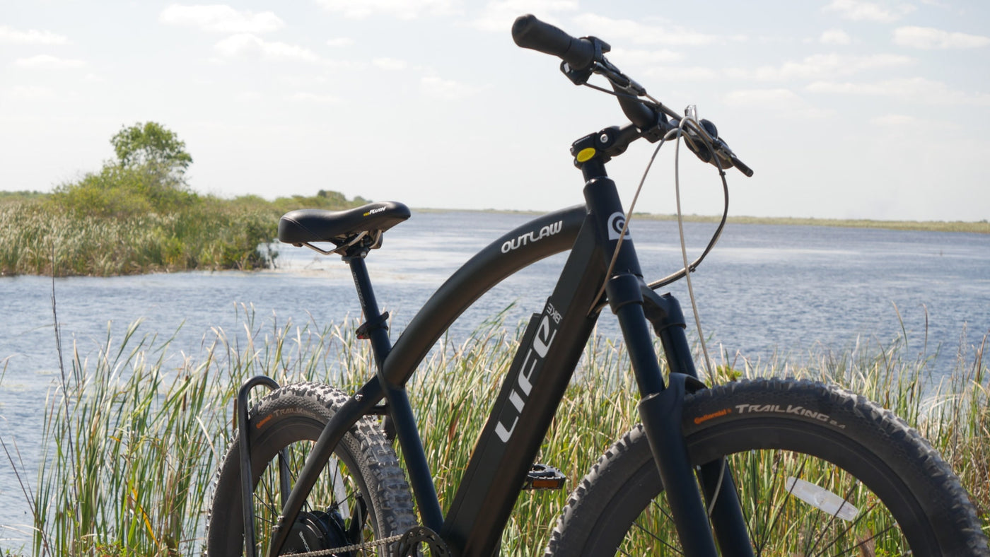 Outlaw 400 ebike is at a lake park.