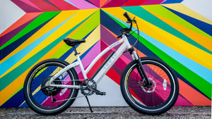 The White Genesis R 400 ebike behind colorful artwork.